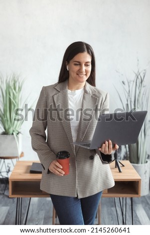 Confident business woman working on laptop and making online video conference at workplace in a trendy modern office. High quality photo