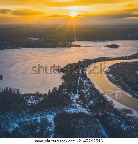 Aerial view of Jugla lake and Jugla chanel in Latvia. Scenic landscape of early spring nature. Melting ice on water. Forest.