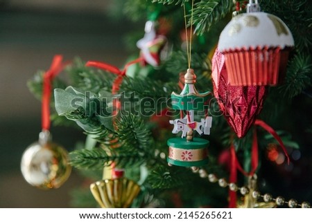 Beautiful decorations and toys on the Christmas tree, red and gold. Close-up, details of the Christmas tree.