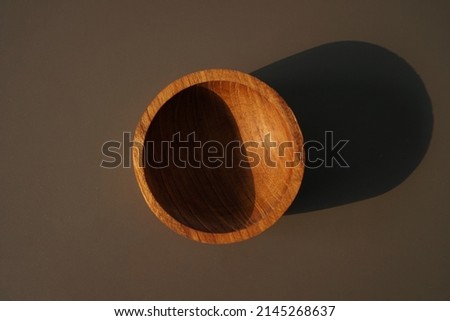 Isolated wooden bowl on brown background