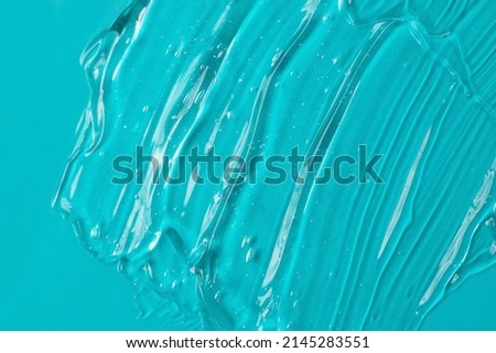 Background from turquoise textured cosmetic gel.Top view,antibacterial liquid surface.Good as background or mockup.