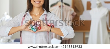 Crop narrow banner of woman seamstress or tailor show love heart hand gesture or sign with threads. Smiling female dressmaker or designer feel affectionate about fashion atelier business. Royalty-Free Stock Photo #2145313933