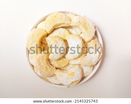 Kue putri salju or vanillekipferl or italian crescent cookies or greek almond shortbread or kourabiedes. served on white plate. sweet taste. isolated background in white. 