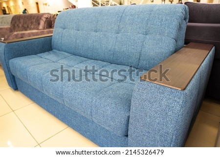 Soft new blue modern comfortable sofa with wooden armrest Royalty-Free Stock Photo #2145326479