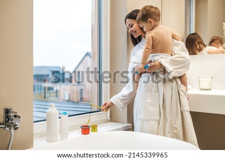 Joyous young mother playing with her child
