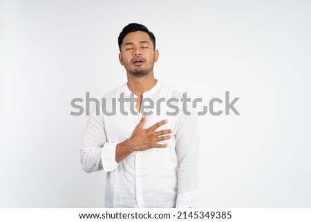 calm man with chest hands while feeling comfortable and relieved Royalty-Free Stock Photo #2145349385