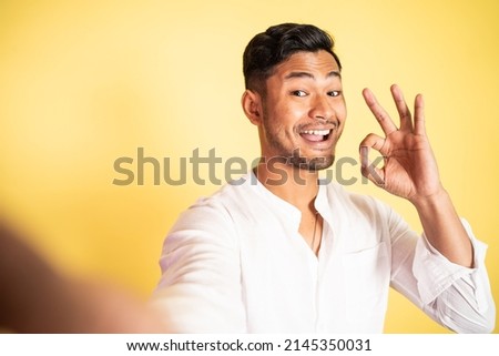 young man selfie with finger gesture okay on isolated background