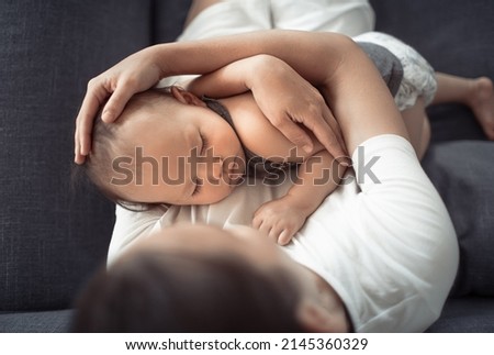 Loving caring mother holding her baby girl in her arms. top view.