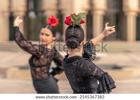 Flamenco ballerina on her back with bun hair and a rose on her head Royalty-Free Stock Photo #2145367383