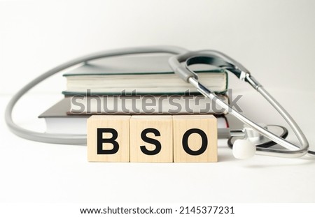 BSO the word is written on wooden cubes,plant and red pills,on white background