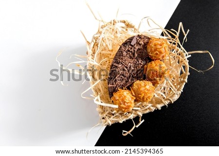 Chocolate filled easter eggs on black and white background top view
