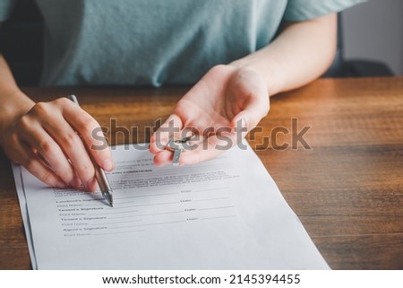 Lease agreement document concept. Realtor or broker showing to signature the tenant's document paper with pen and key, Rental agreement form, signing hand, agreement.