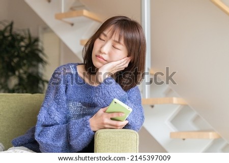 Young attractive Asian woman using a smartphone,think,