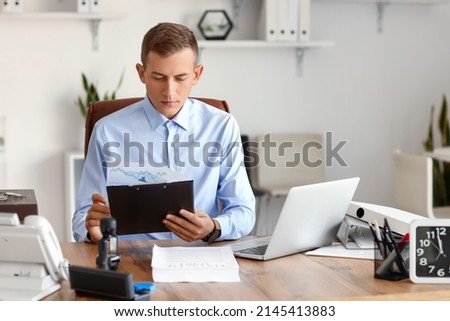 Young male notary public working in office Royalty-Free Stock Photo #2145413883