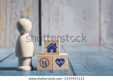Wooden doll figure and wooden cube with house, food and heart icon. Life concept