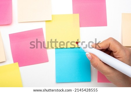 Hand written notes red marker sticker notes paper. hand with red marker ready to write. Many colored empty sticker notes on wall. Business people meeting and use notes to share idea on sticky note. Royalty-Free Stock Photo #2145428555