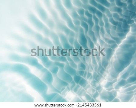 Closeup​ metal​ texture​ of​ surface​ blue​ water​ reflected​ by​ sunlight​ for​ background. Blue​ water​ texture​ in​ the deep​ sea​ for​ background.Reflection​ on​ surface​ blue​ water​ in​ big sea.