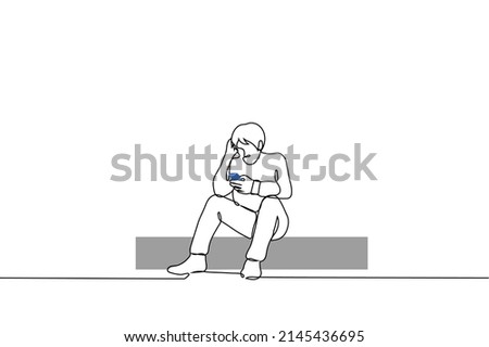 man sits on curb and looks into the phone scratching his head with his free hand, he is puzzled or even sad - one line drawing vector.  concept of news intoxication, news reading, internet surfing