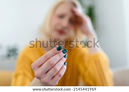 Young woman holding wedding engagement ring in hands, engaged girl doubts about marriage proposal, abandoned wife depressed after getting divorced, help to overcome breaking up, starting new life