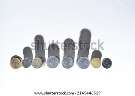 Indian coins are stacked in paper surface. Concept of Saving money, economy, investment, growing business and wealth. Overhead view, flat lay. 