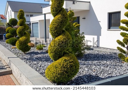 Modern and well-kept front garden with decorative chippings and Mediterranean planting Royalty-Free Stock Photo #2145448103