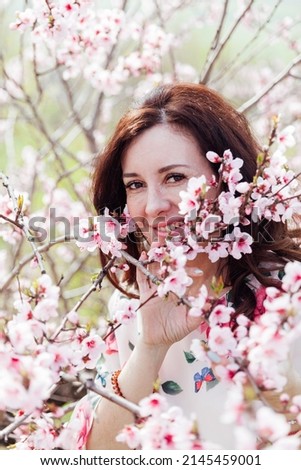 a woman in a garden of flowering trees in spring