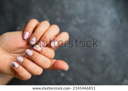 Women's hands with colorful pattern on the nails. 2022 colors trend. Top view. Place for text. 