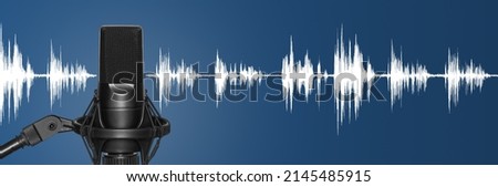 Modern studio microphone with audio waveform over blue background. Radio broadcast or podcast banner Royalty-Free Stock Photo #2145485915