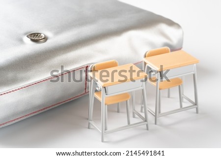 disaster prevention hood on white background.
Miniature school desk and chair.