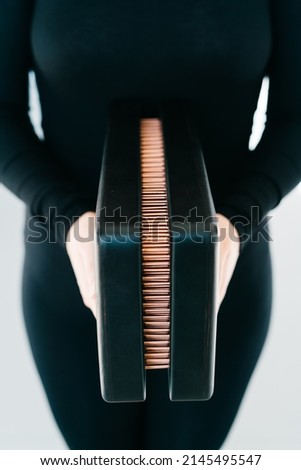 a sadhu board of their dark solid oak with copper nails, in the hands of a young girl on a white background. yoga practice standing on nails. High quality photo