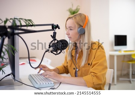 young woman is streaming while sitting in coworking at the computer
