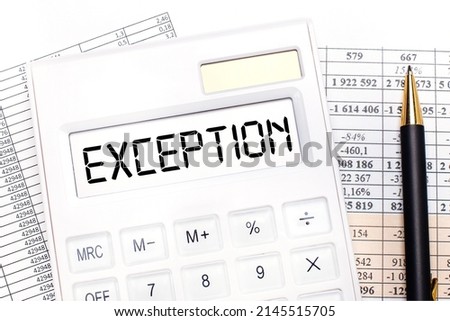 On the desktop there are reports, a white calculator with the text EXCEPTION on the scoreboard and a pen. Business concept.
