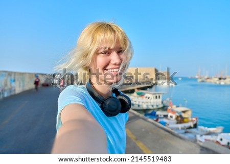 Close-up face of happy teenage girl taking selfie portrait