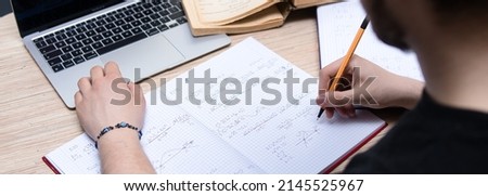 the student solves math problems. Calculating the derivative. Learning advanced mathematics in college Royalty-Free Stock Photo #2145525967