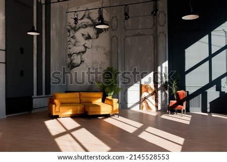 Modern loft living room with high ceiling, black and grey walls, wooden floor, design furniture and tropical plant Royalty-Free Stock Photo #2145528553
