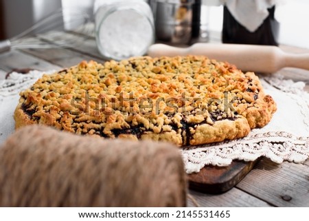 Appetizing grated pie with jam on a napkin. Close-up of a baked pie with a golden crust.
