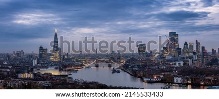 Wide panoramic view of the 2022 skyline of London with City, Tower Bridge and skyscrapers during a moody evening