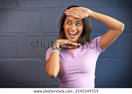 Life is more fun when you think outside the box. Shot of a young woman gesturing with her hands against a brick wall background.