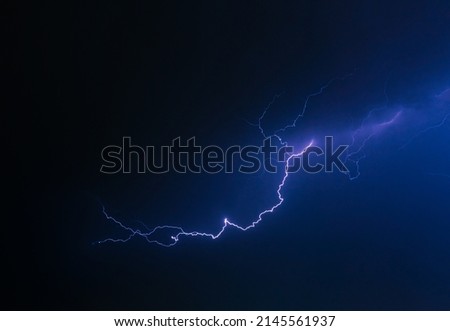 Flashing lightning in the dark sky. Lightning marks appearing over the city. Light beam that stands out with dark background.