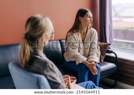 Sad frustrated woman talking in a session with a psychotherapist about her problems. Royalty-Free Stock Photo #2145564911