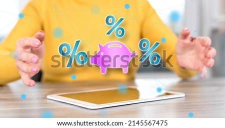 Digital tablet with interest rates concept between hands of a woman in background