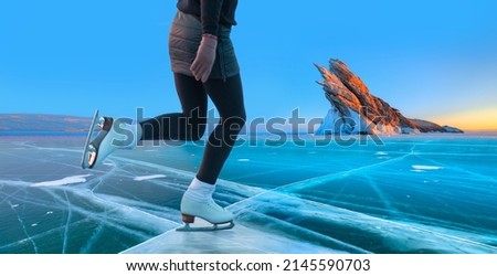 A young happy woman is skating on the transparent ice of the frozen Lake Baikal on a sunny winter day