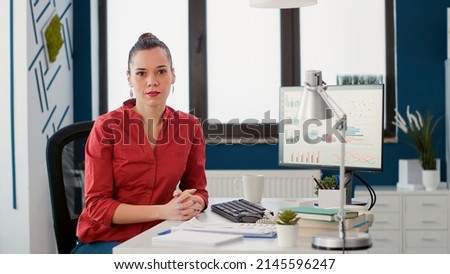 Portrait of project manager sitting at office desk to work on business growth with financial charts and sales statistics. Marketing consultant analyzing e commerce diagrams on computer.