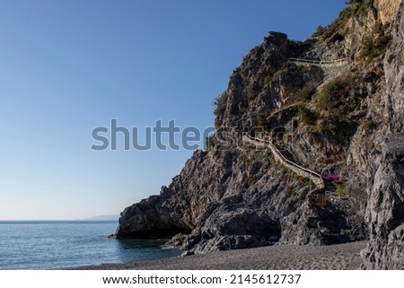 Ancient Stone Staircase on a Rock on the Shore of the Beautiful Tyrrhenian Sea in Calabria, South of Italy. Old stone stairs on the beach. Healthy and active travel concept.