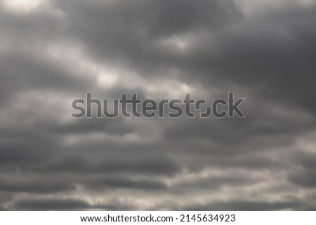 Natural background of dramatic dark stormy clouds in gray sky