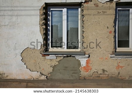 facade of the building fallen off plaster plastic window