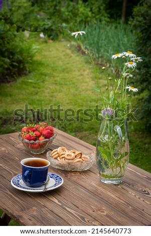 Tea drinking in the garden. Tea, bagels, strawberries, wildflowers