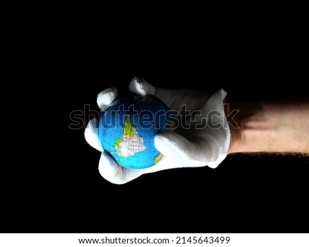 Planet Earth and a Hand on a Black Background