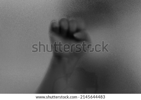 sign language hands clenched symbol. Shadow hands of the Man behind frosted blurred glass. Blurry hand abstraction. black and white halloween