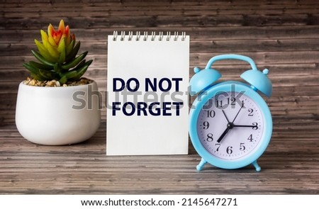 Don't forget reminder on notepad and wooden background